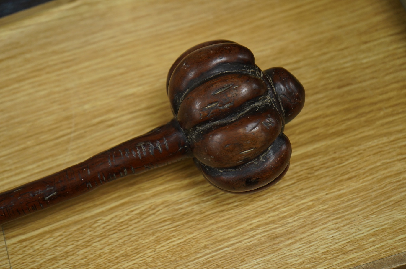 A 19th century Fiji carved hardwood throwing club, Ula, 40cm long, swollen head divided into nine segments, the handle carved with zigzag decoration and incised lines. Condition - good.